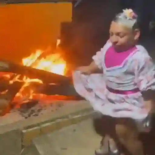 Figurinha: Criança dançando na fogueira
