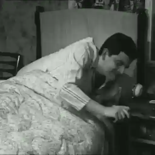 Figurinha: Homem com revólver na cama