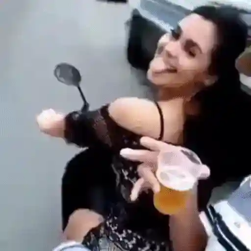 Figurinha: Mulher com copo de cerveja na moto