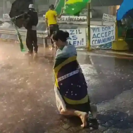 Figurinha: Mulher ajoelhada com bandeira do Brasil